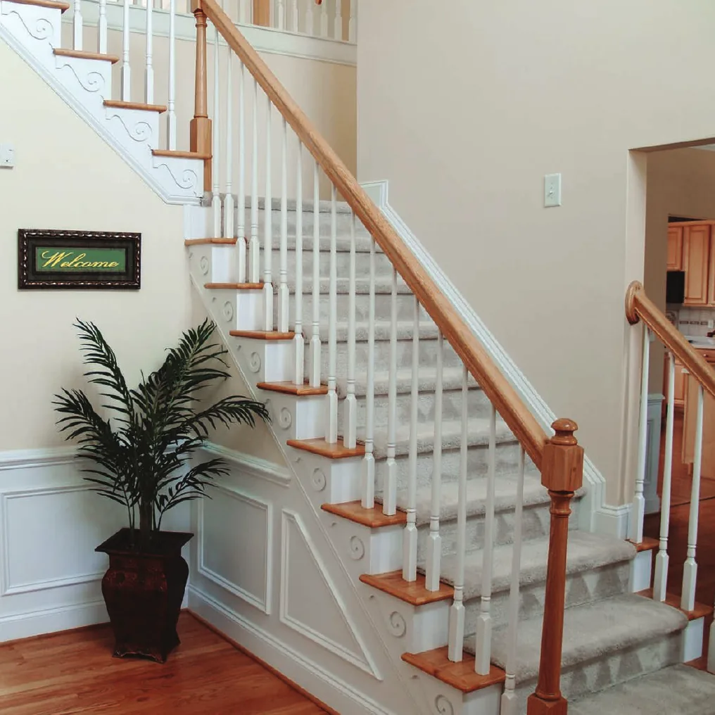Colonial staircase with white turned balusters, oak handrail, and a starting newel