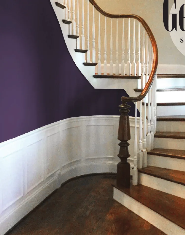 Georgia-style curved staircase with white turned balusters and a stained starting newel
