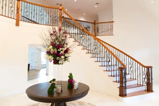Finished oak staircase with iron balusters and a matching wood handrail