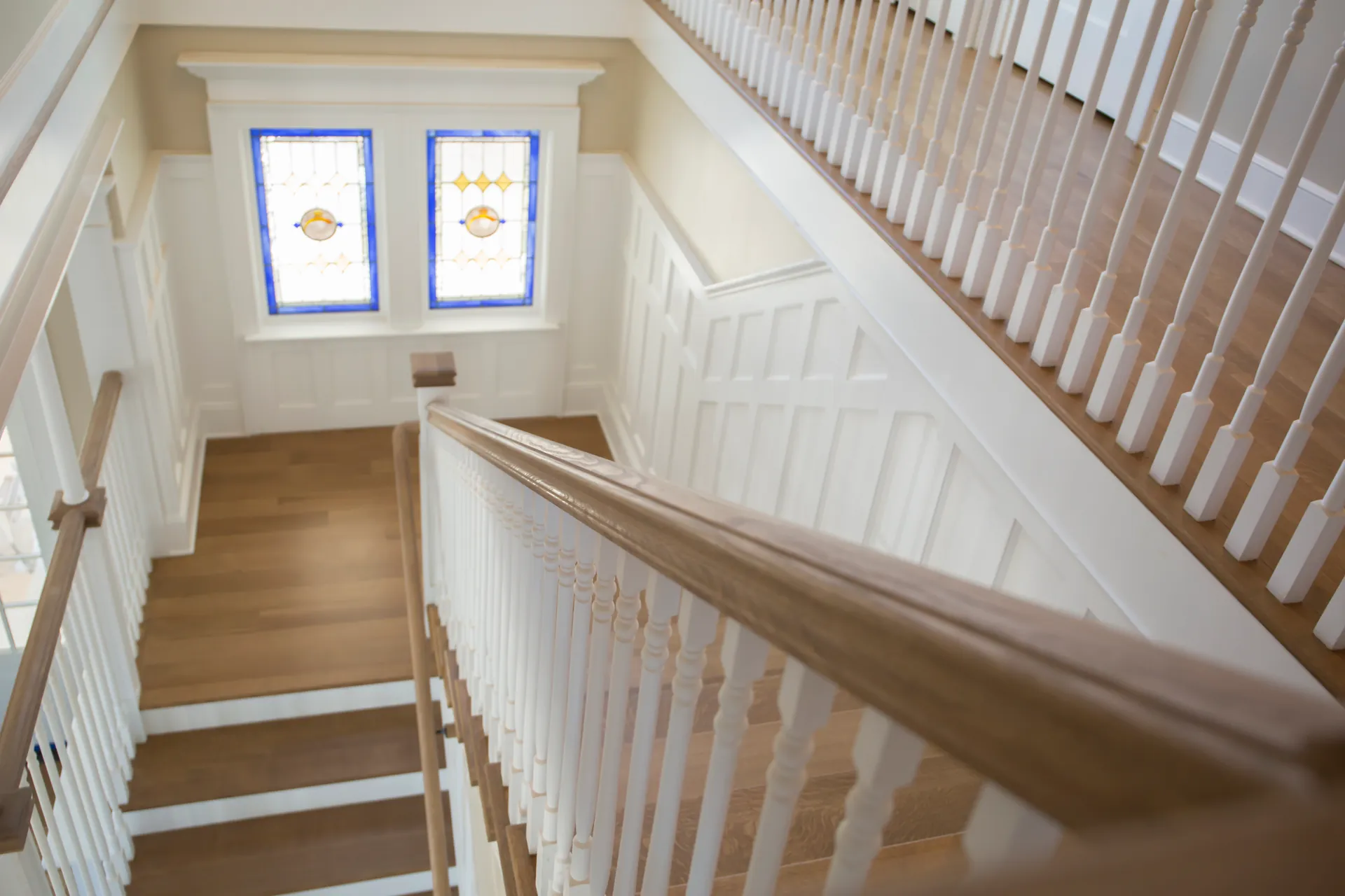Finished wood staircase with coordinated iron balusters and handrail